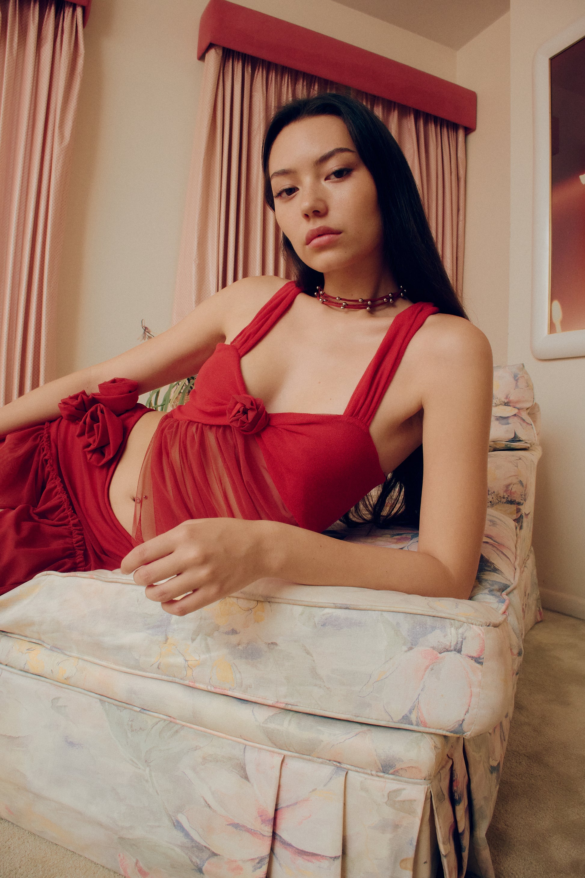 The Red Talk mesh flower asymmetric top adds an effortless yet bold and iconic touch to your wardrobe. The center rosette decorations provide an elegant focal point.