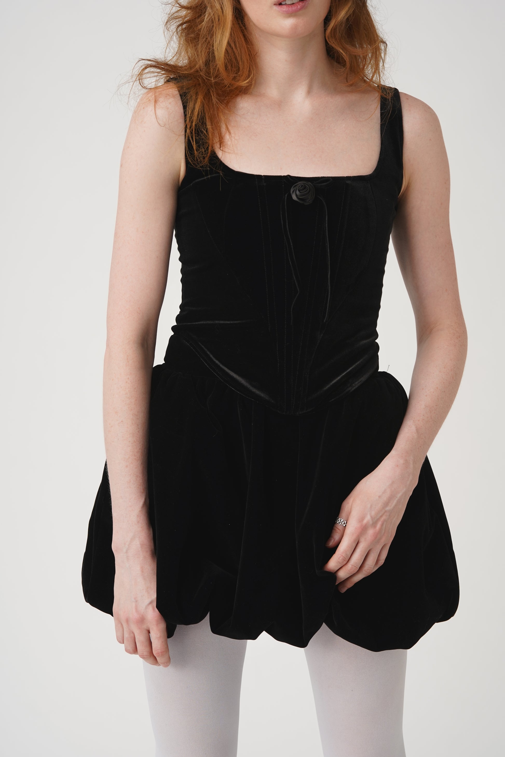The fairytale doesn’t end at midnight with this fully lined corset top that has a velvet construction with satin center rose and velvet lace detail, an square neck design, and a back center closure.